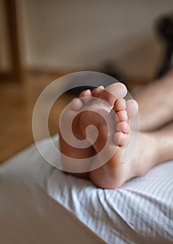 Legs of a man sleeping in bed