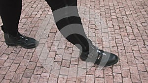 legs man walk along stone pavement Locomotion person moving around city