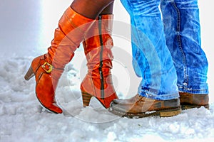 Legs Man and woman in winter boots standing in the snow.