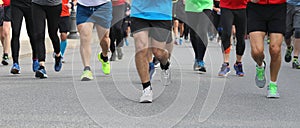 legs of many runners at footrace in  the city
