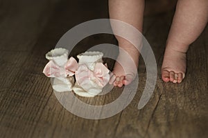 Legs of newborn baby close up on wooden background