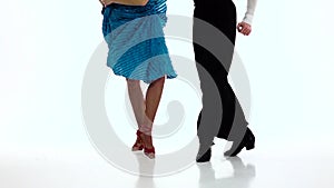 Legs pair ballroom dancers perform salsa, white background. Slow motion