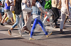 Legs of the pedestrians crossing on city street