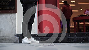 Legs of people walking on busy city street, close-up view