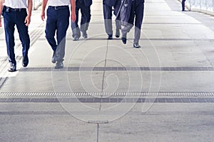 legs of people walking on sidewalk on rush hour