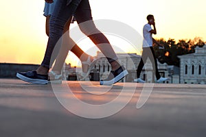 Legs of people walking at sunset