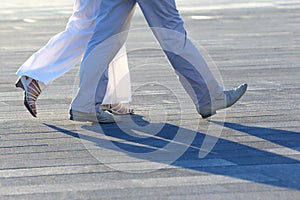 Legs of people walking at sunset