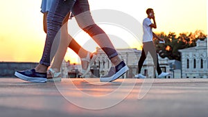 Legs of people walking at sunset. Leisure and recreation