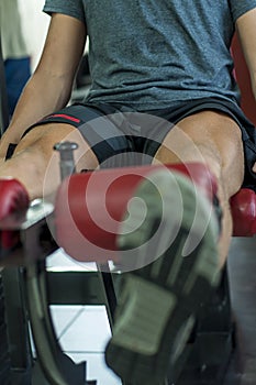 Legs of a person exercising on the quadriceps machine at the gym