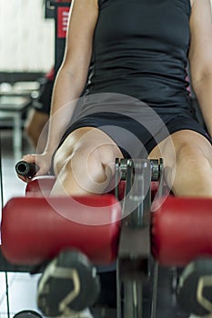 Legs of a person exercising on the quadriceps machine at the gym
