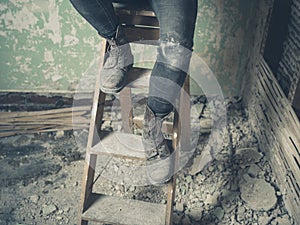Legs of person sitting on stepladder