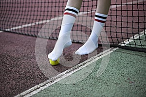 Legs of a person in white socks in front of a tennis net
