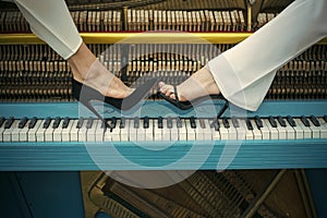 Legs on piano keyboard blue color, fashion.