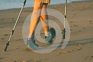 Legs and poles of nordic walker old woman