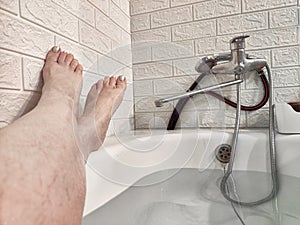 Legs during Relaxing Bath Time in a Tranquil Home Bathroom. Person enjoys a moment of relaxation, with their legs