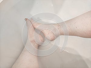 Legs during Relaxing Bath Time in a Tranquil Home Bathroom. Person enjoys a moment of relaxation, with their legs