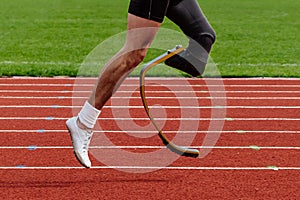 legs runner para-athlete on prosthesis running red track stadium