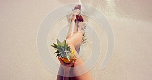 Legs, sand and relaxing at beach on vacation, peaceful and zen at tropical destination or holiday. Person, fruit