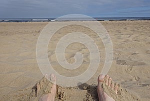 Legs on the sand and with sand on the foot