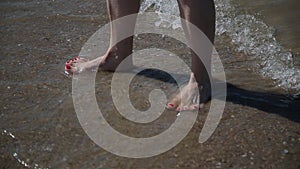 Legs in sea water, with an influx of waves.