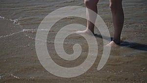 Legs in sea water, with an influx of waves.