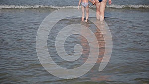 Legs in sea water, with an influx of waves.