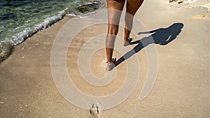 Legs of a sexy young woman walking on a white sandy beach in the Riviera Maya