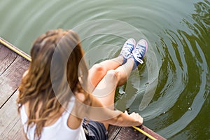 Legs in sneakers making circles in a water