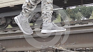 Legs in sneakers and trousers of protective go on rails