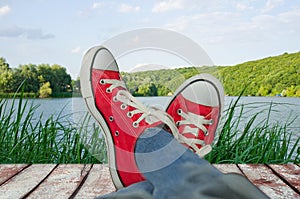 Legs in sport shoes on holiday, with a view of nature