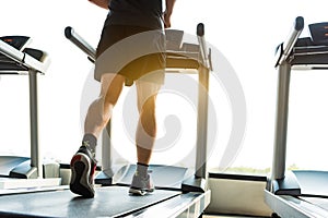 Legs of sportsman running on treadmill in fitness gym center. Sport and Healthy lifestyle concept. People workout and exercise