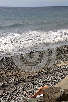 Legs of sunbather on beach