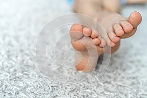 Legs of a teenager lie on a soft carpet. Rest after wearing uncomfortable shoes. Close-up