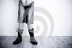 Legs of teenager with wet pants and boots