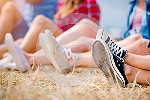 Legs of teenagers, canvas shoes, summer music festival