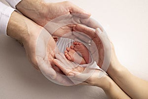 Legs, toes, feet and heels of a newborn. Hands of parents holds the child& x27;s legs