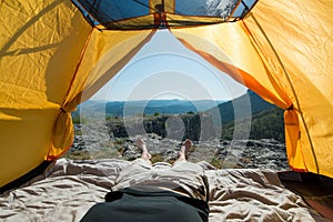 Legs of the traveler in an camping tent outdoors