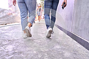 Legs of two person walking through a shopping mall