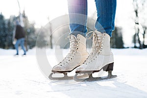Legs of unrecognizable woman ice skating outdoors, close up.