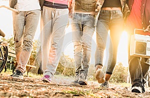 Legs view of friends walking in city bike park with backlight