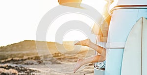 Legs view of happy surfer girl inside minivan at sunset - Young woman having fun on summer vacation - Travel,sport and nature