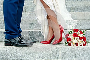 Legs of wedding couple and bouquet