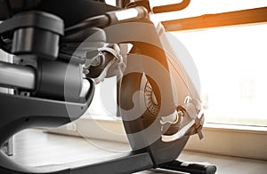 Legs of woman biking in gym, exercising legs doing cardio workout cycling bikes