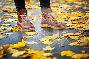 Legs of a woman in brown boots in autumn park