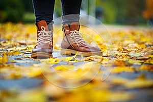 Legs of a woman in brown boots in autumn park