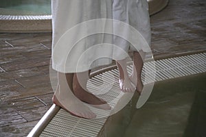 Legs of a woman and a child near the pool in a spa center