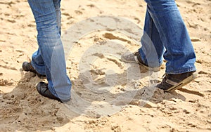 Legs of woman and man on the beach in summer