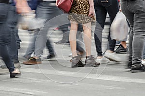 Legs of a woman standing in the middle of a crowd