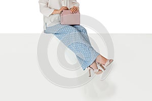 Legs woman wearing high heels shoes sitting on bench.