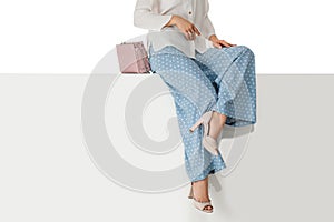 Legs woman wearing high heels shoes sitting on bench.